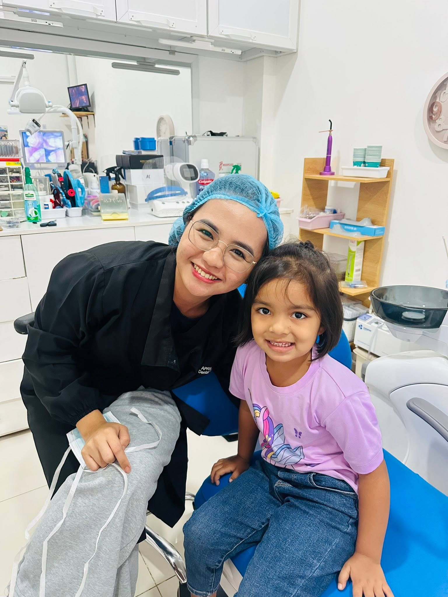 Dr. Gacutan sharing a smile with a young patient in the clinic
